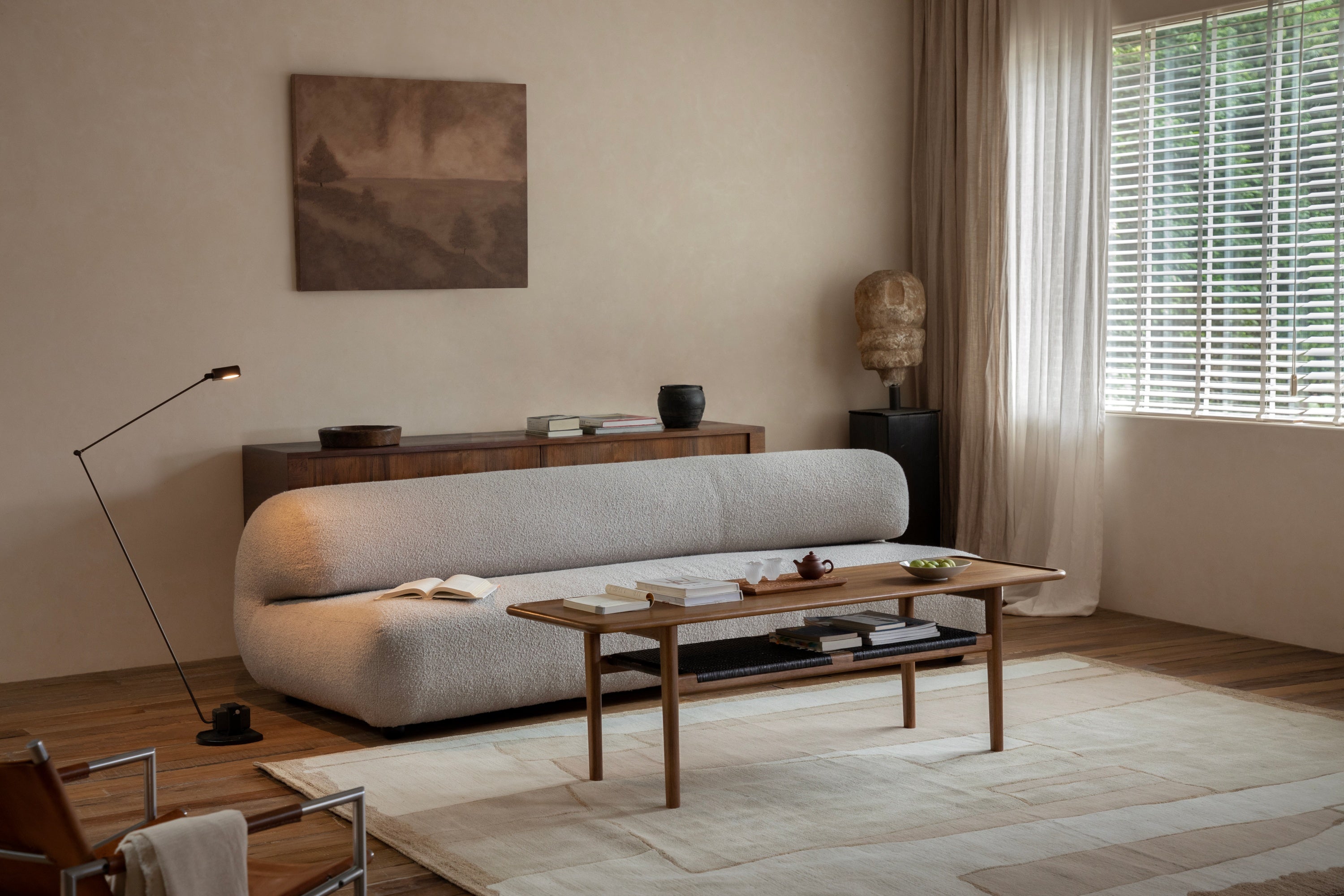 Minimalist living room with a low wooden coffee table and a curved sofa.