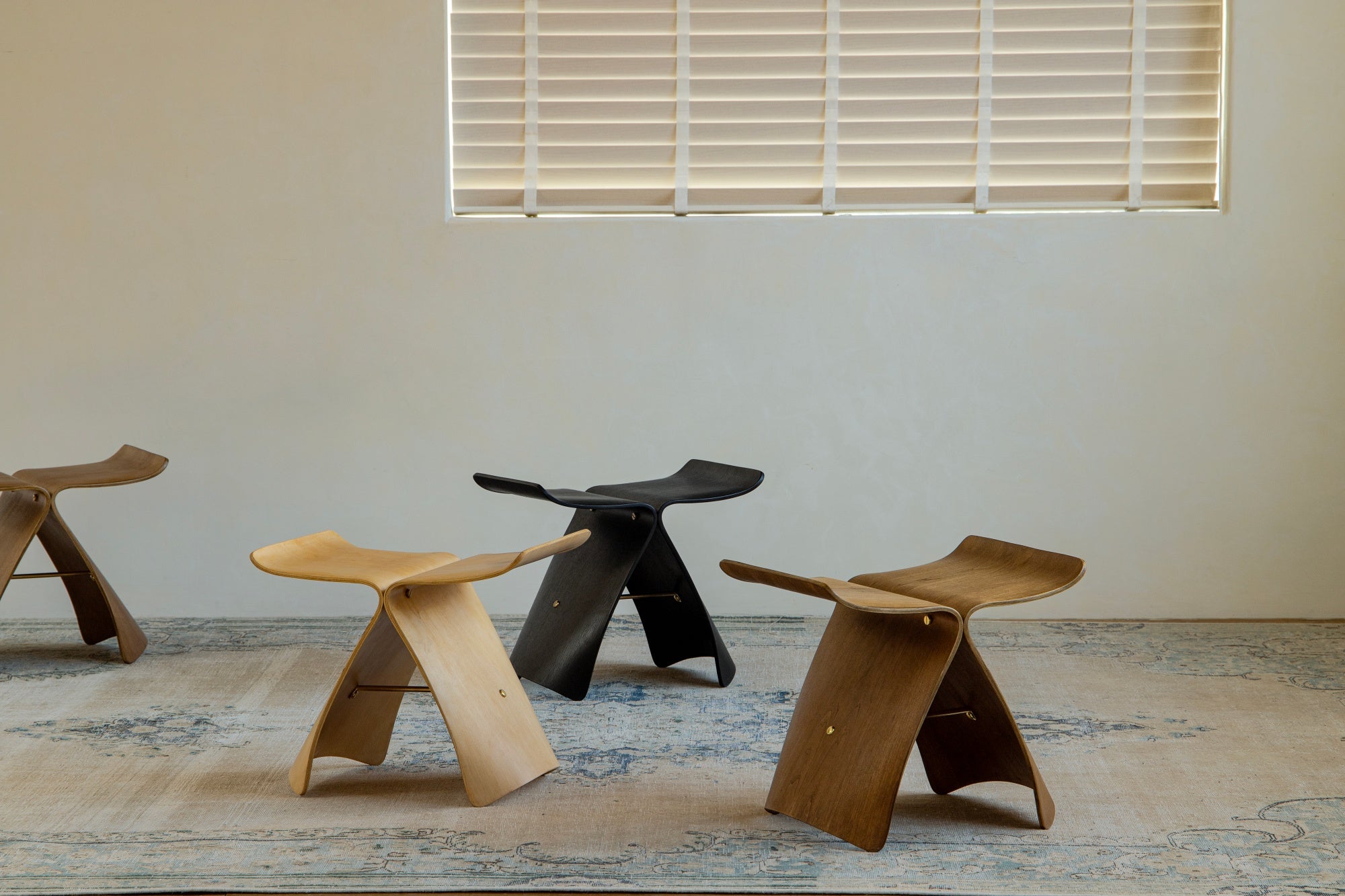 Collection of curved wood design accent stools in various finishes