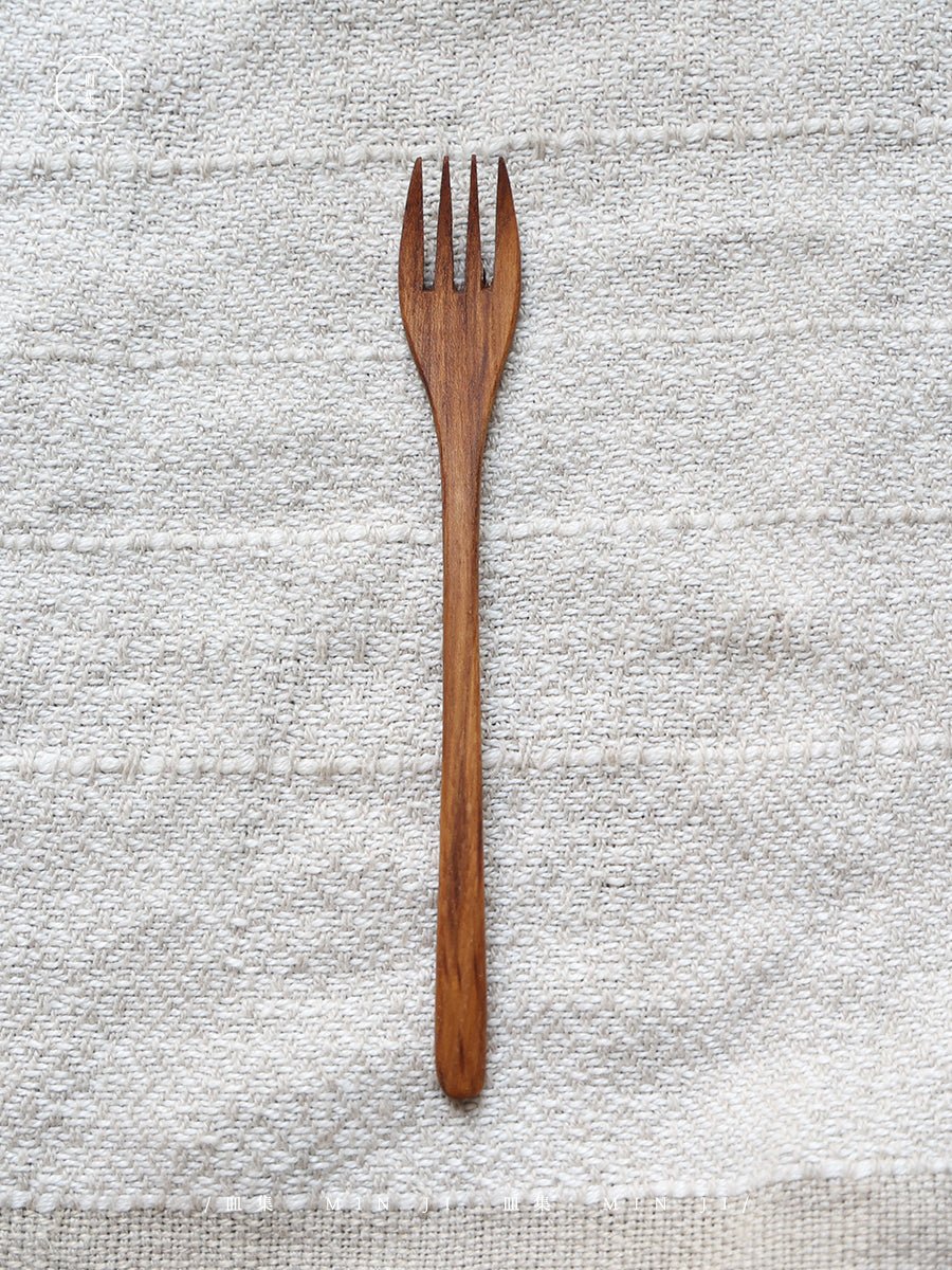 Single wooden fork, natural wood grain, perfect for eating. Part of the MIN JI product line, eco-friendly cutlery.