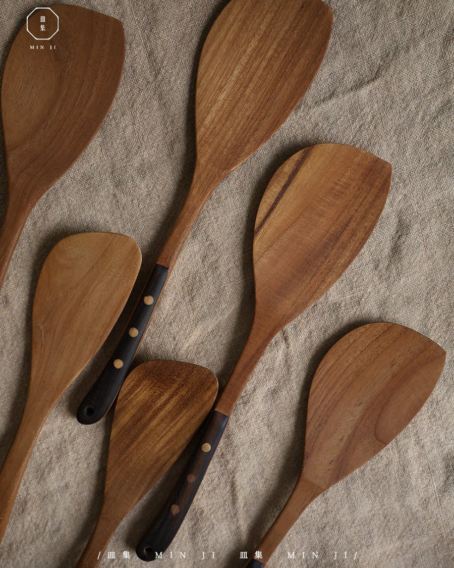 MIN JI teak wood fried spatulas and serving spoons with dark studded handles.