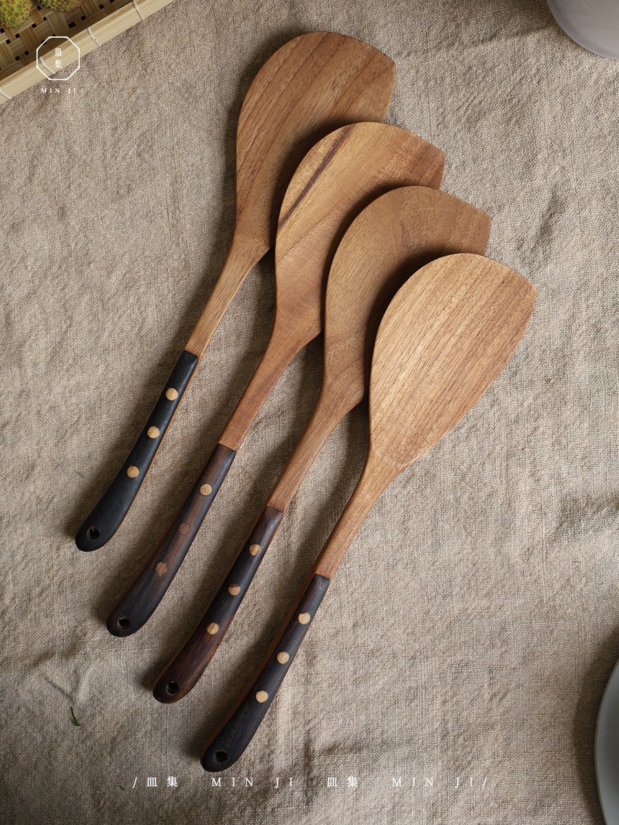 MIN JI wooden fried spatulas set with dark handles on beige fabric