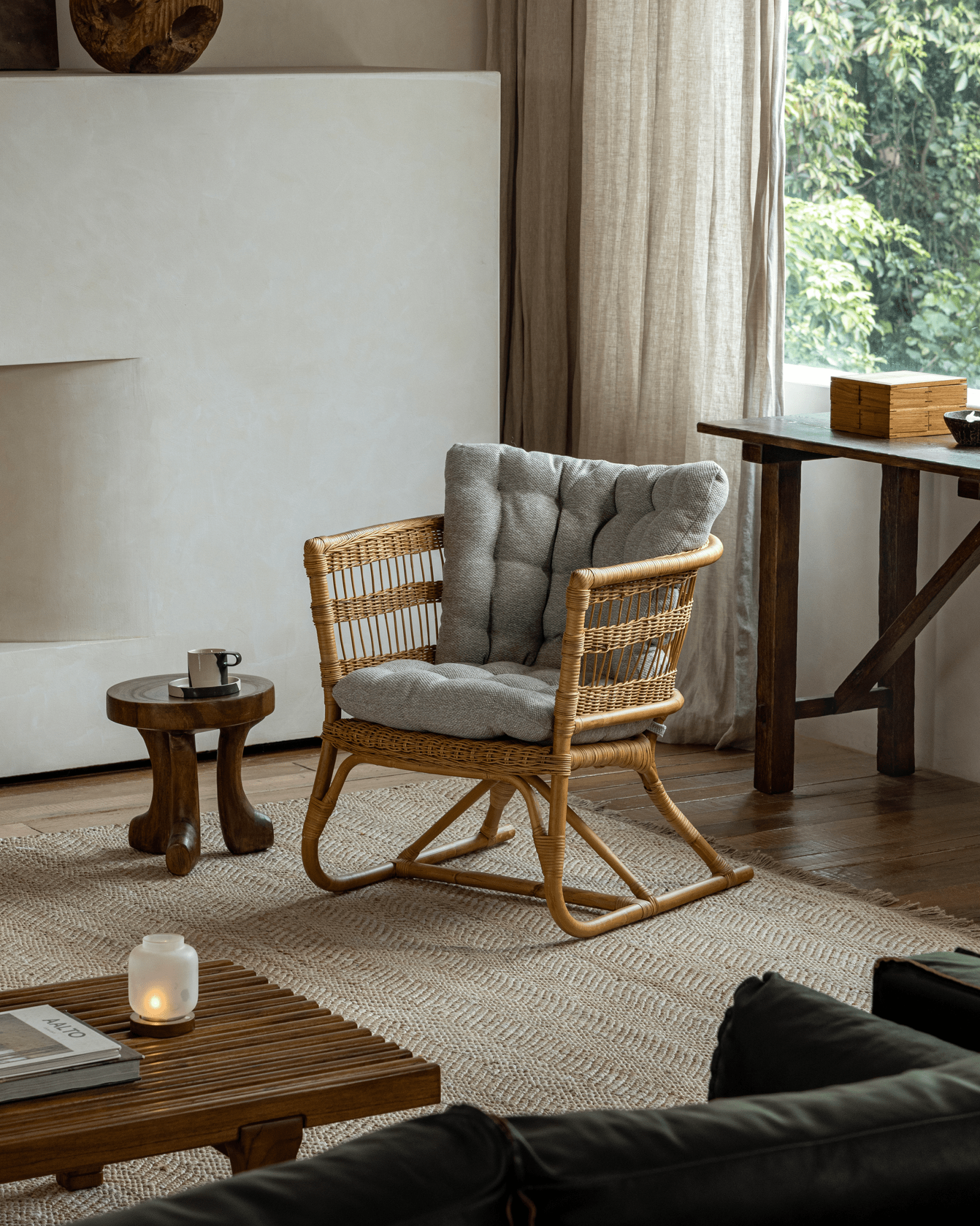 Helian Rattan Chair: Natural rattan frame with gray cushion in a stylish interior setting