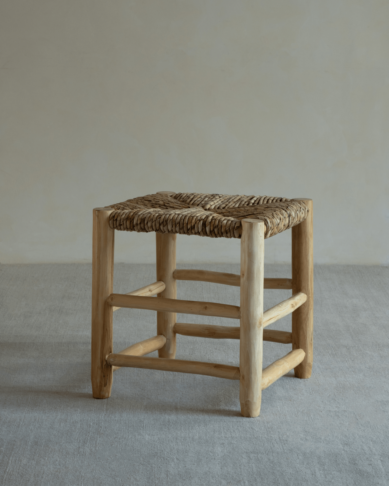 Isla Handwoven Stool with natural wood frame and woven pandan leaf seat. Modern, organic design.