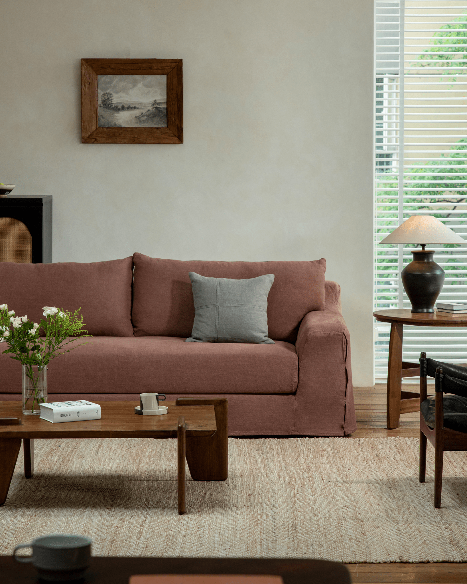 Guni Linen Sofa in terracotta, cozy living room setting with linen fabric, wooden furniture, and natural textures