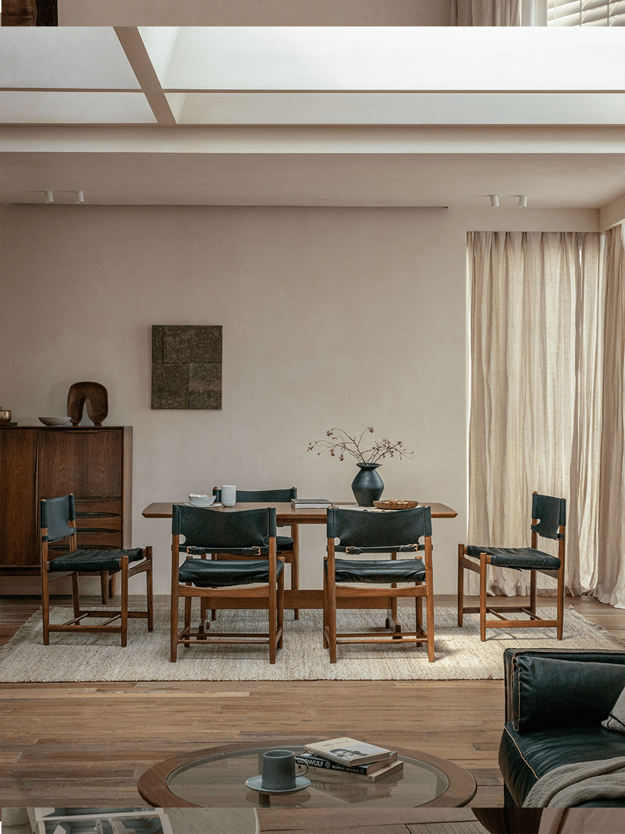 Spanish Dining Chair arrangement: Black leather and teak wood chairs around a dining table, durable design.