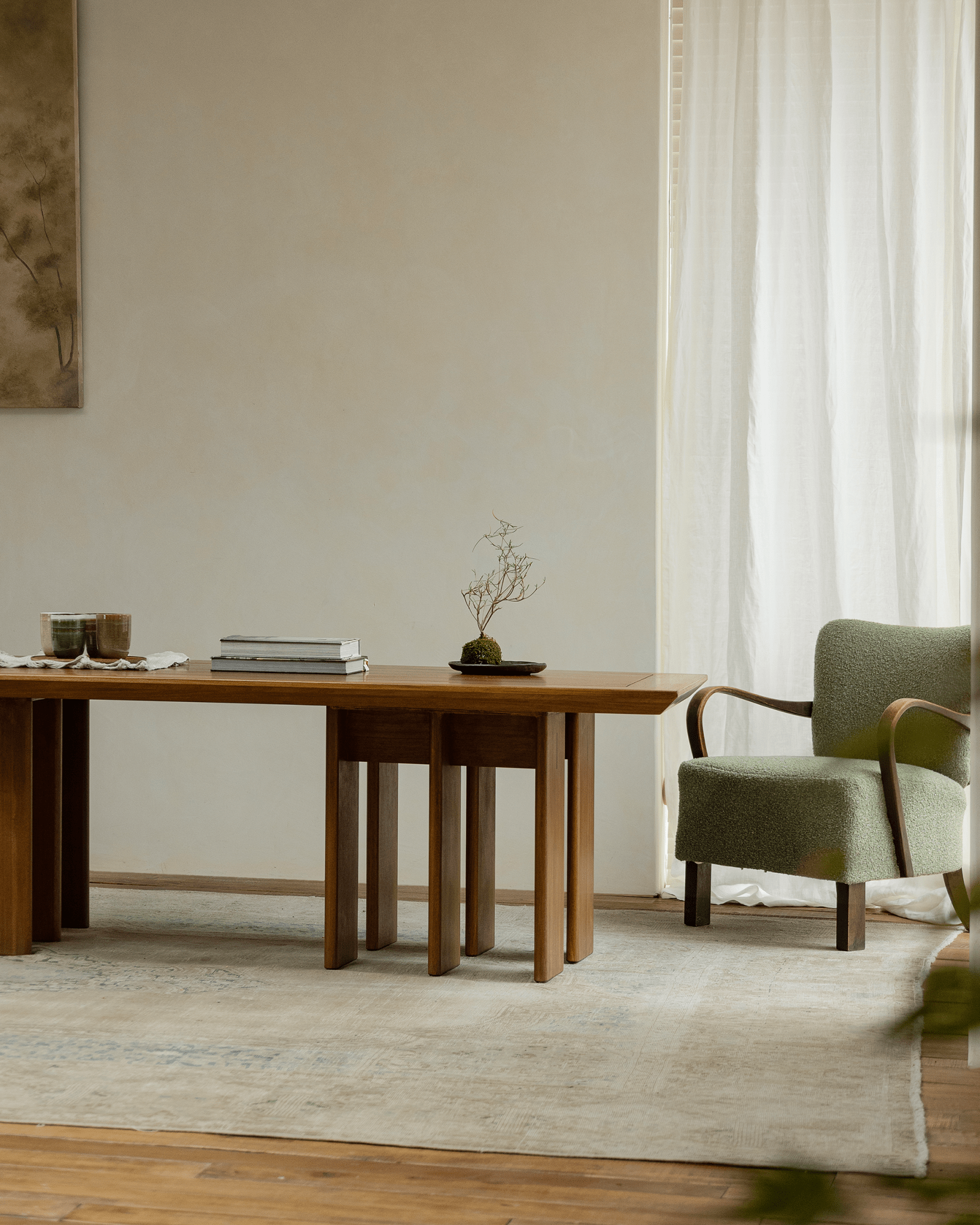 Titan Teak Dining Table in modern interior with green armchair, multi-leg design, and natural light, teak wood