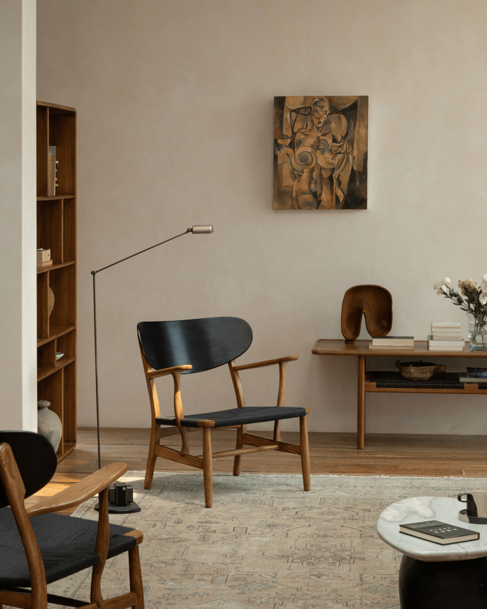 CH22 Lounge Chair with black backrest and oak frame in modern living room; Scandinavian design.