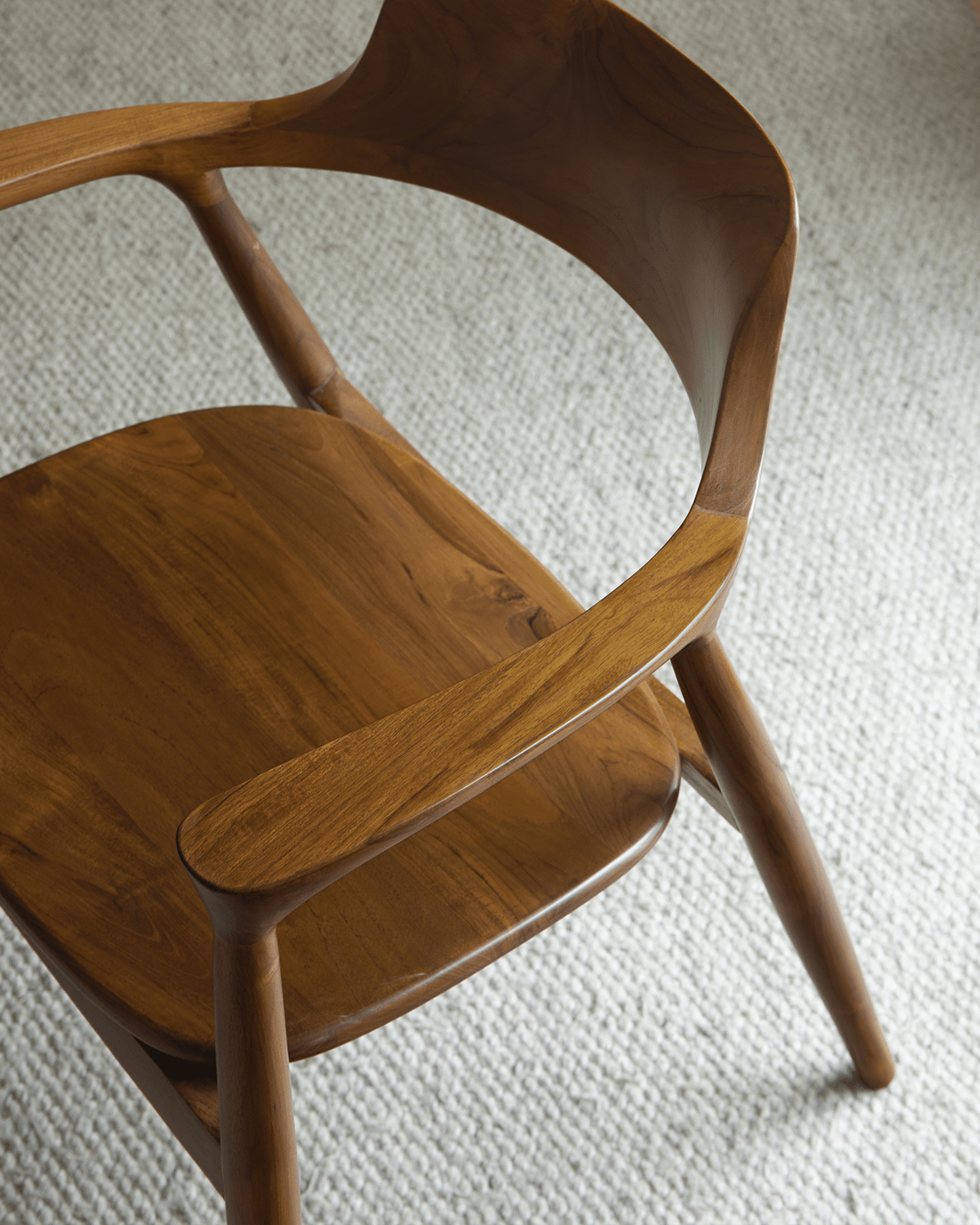 Hiroshima chair made of solid wood, showcasing its curved back and armrests, perfect for modern living spaces.