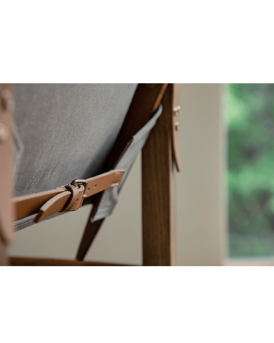 Safari Chair detail: Leather strap and buckle on gray fabric and US Red Oak frame