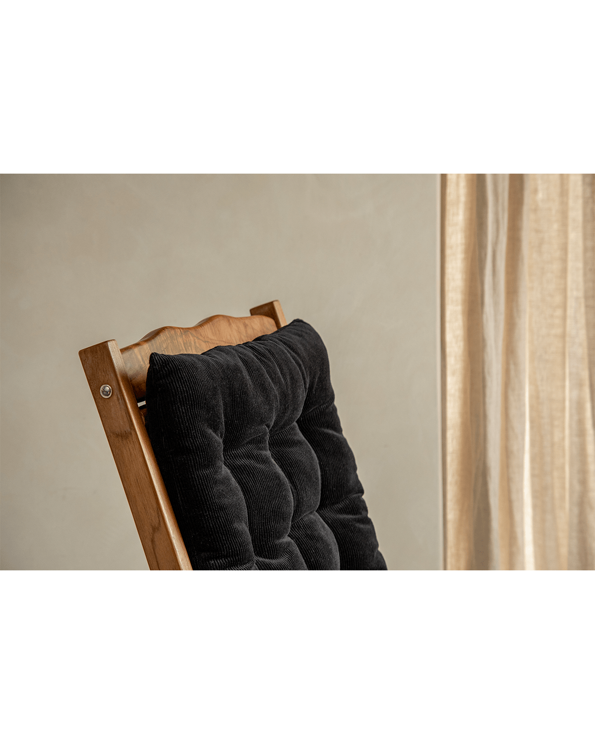 Roller chaise lounge chair back detail with black corduroy cushion and teak wood, ideal for relaxation