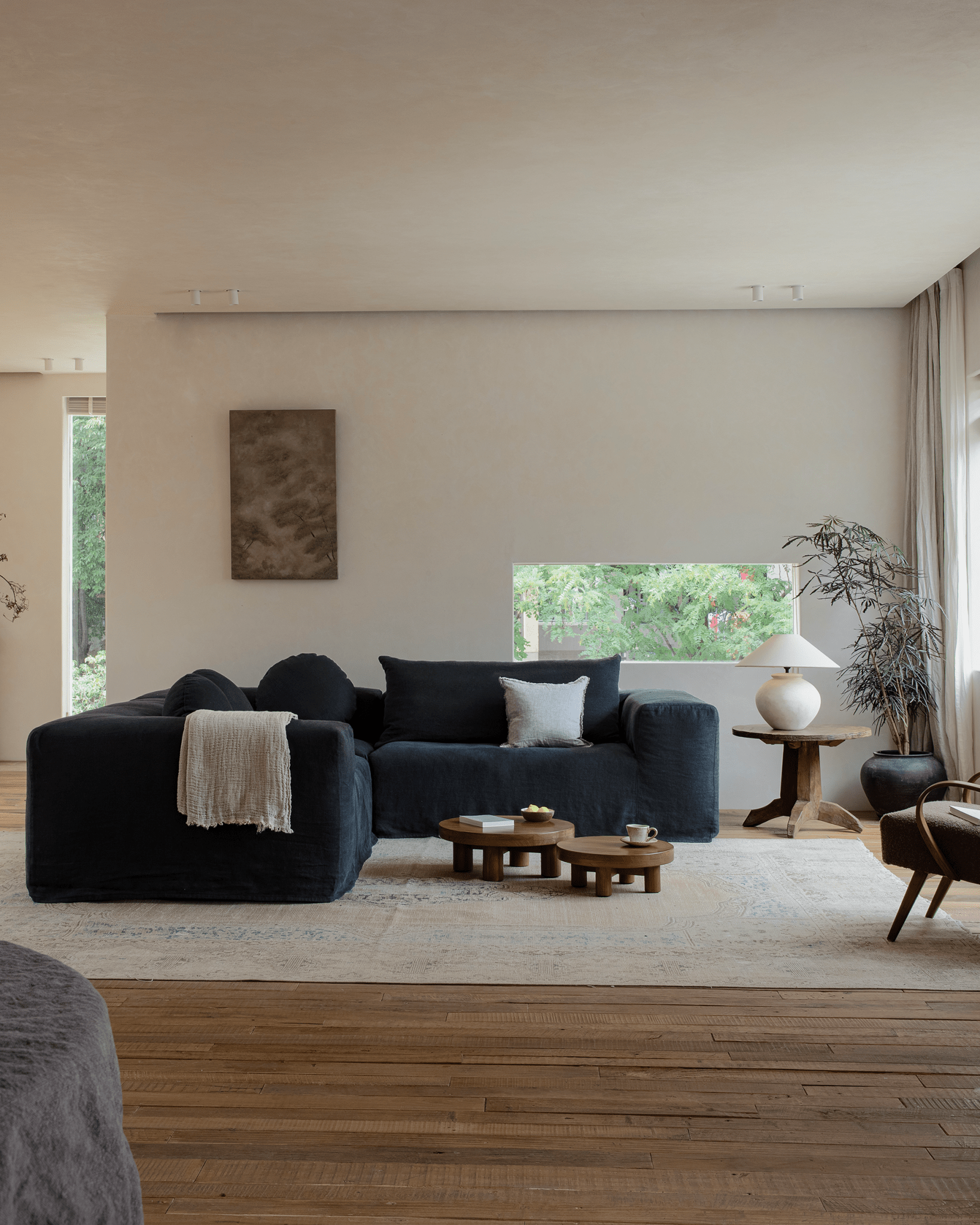 Doma Sectional Sofa in dark linen in a bright, relaxed living room. Modular design.