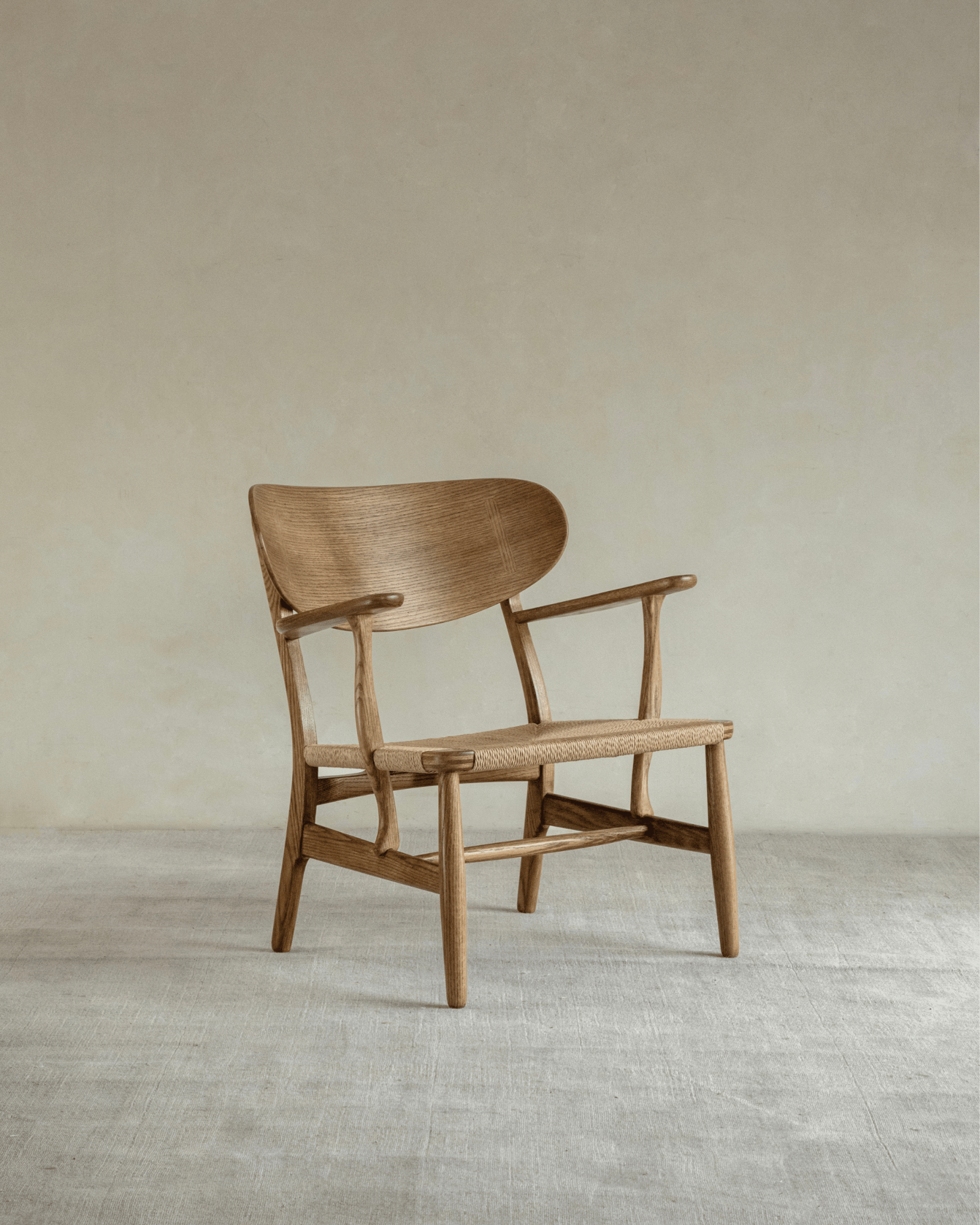 CH22 Lounge Chair in oak with woven paper cord seat. Danish design icon for modern and Scandinavian interiors.
