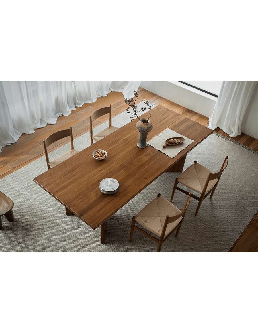 Zephyr Dining Table in natural wood, styled with woven chairs and decor, minimalist design, perfect for bright dining rooms