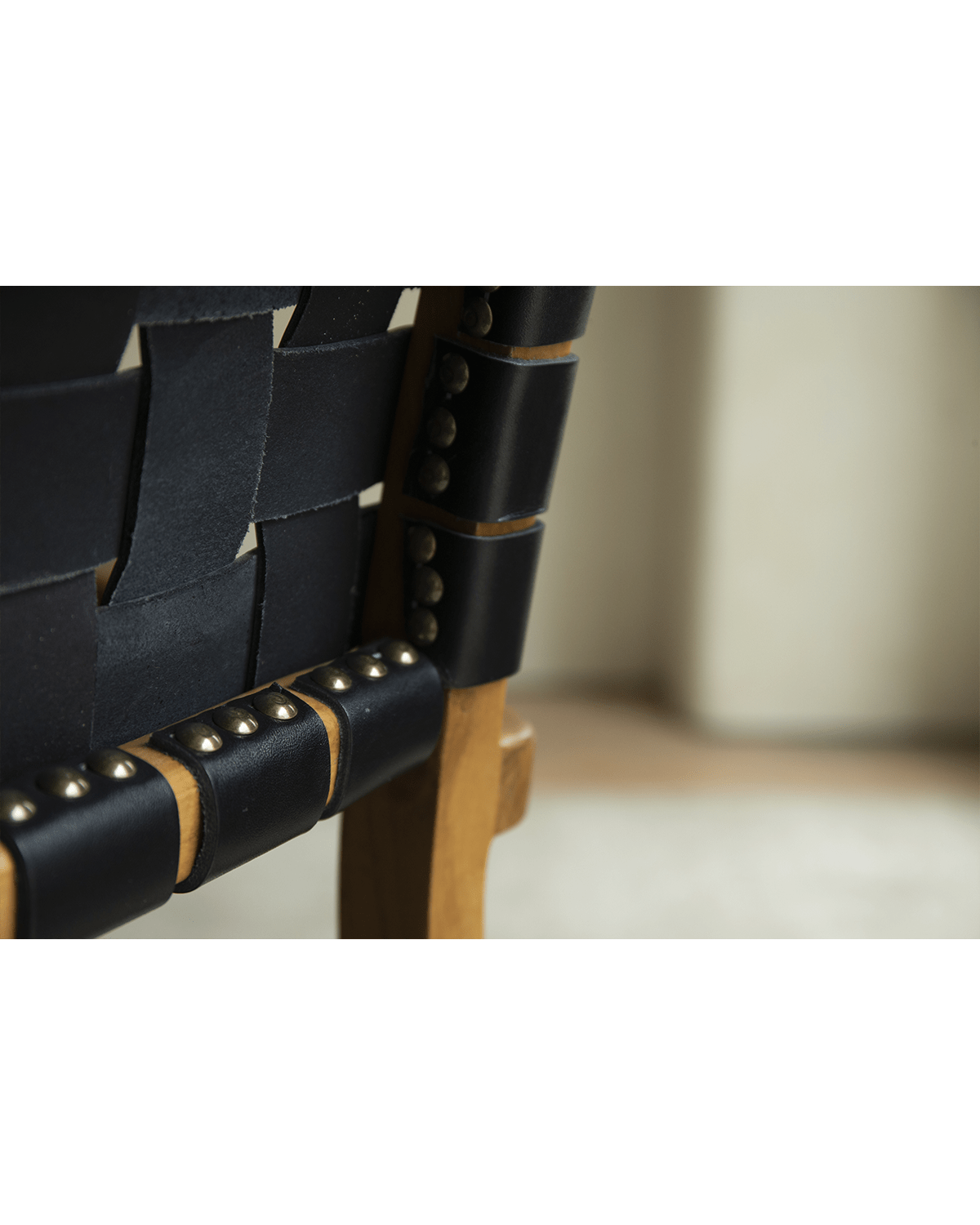 Reed Chair detail: Black leather woven backrest with brass studs, teak frame