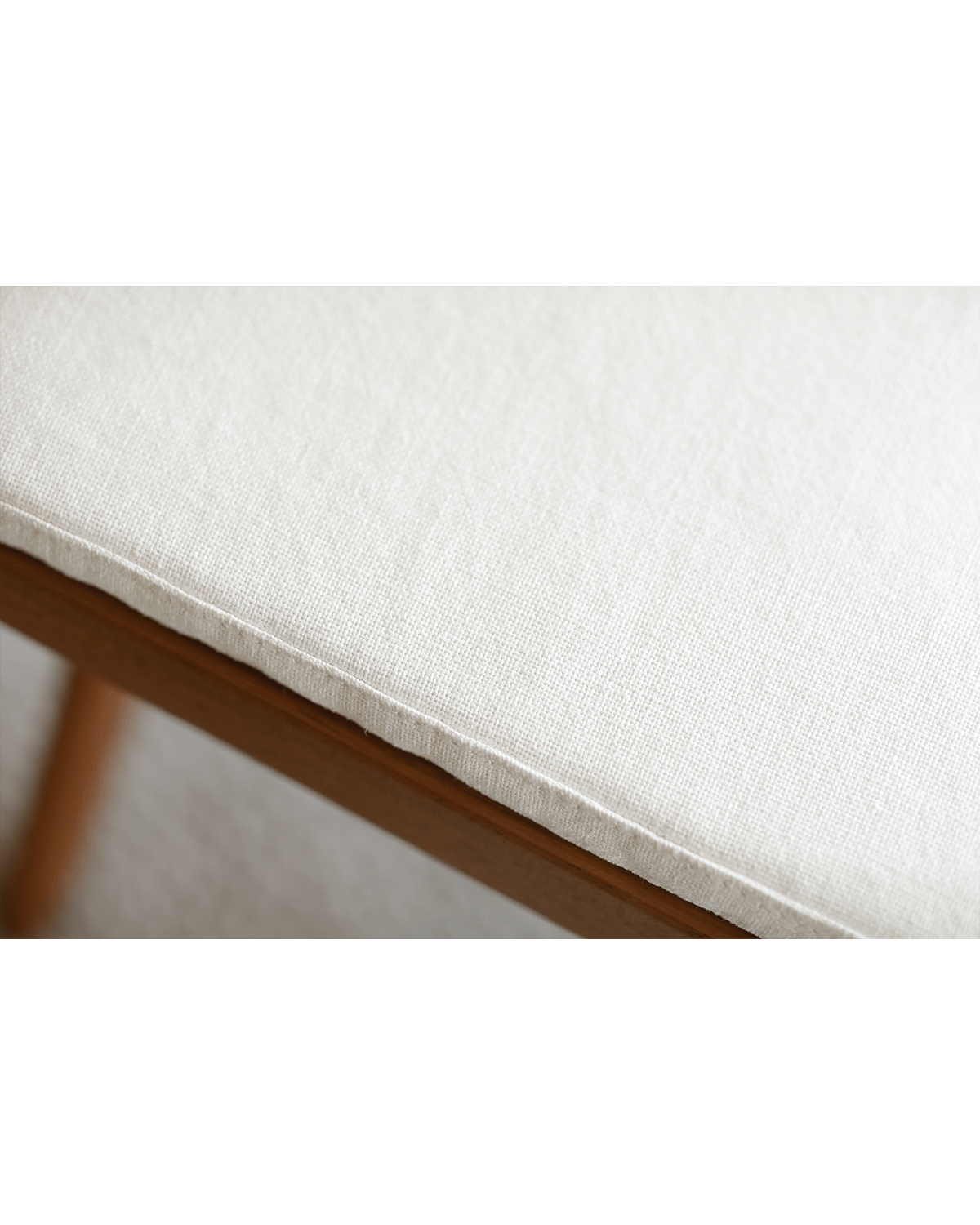 Chandigarh Box Chair detail: White fabric seat cushion on wooden frame