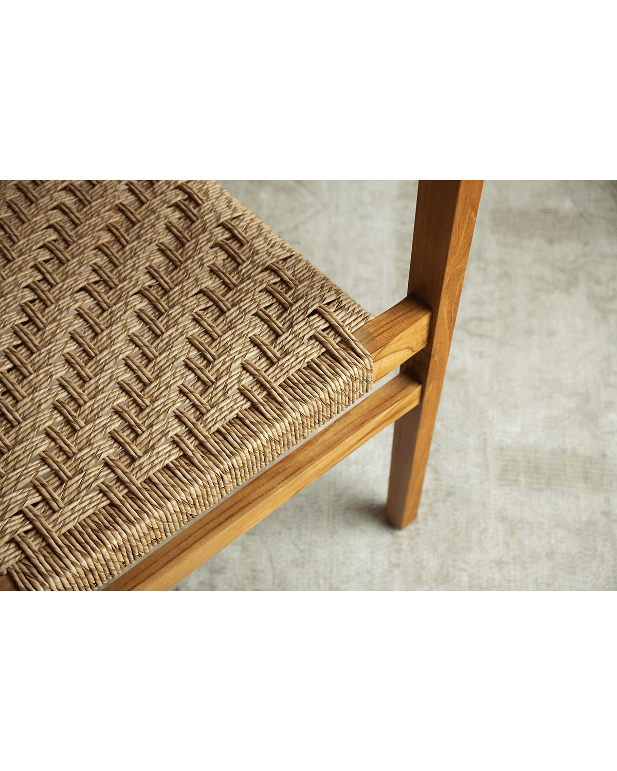 Reed Chair detail: Woven seat and teak frame. Stylish and comfortable seating, ideal for living spaces.
