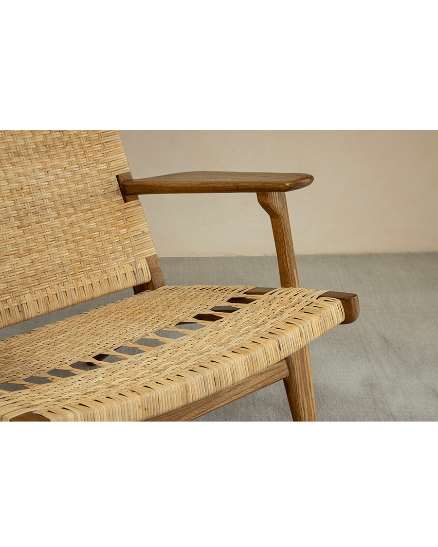 Horn Lounge Chair detail: natural rattan seat and oak frame, ergonomic design. Handcrafted for interior decor.