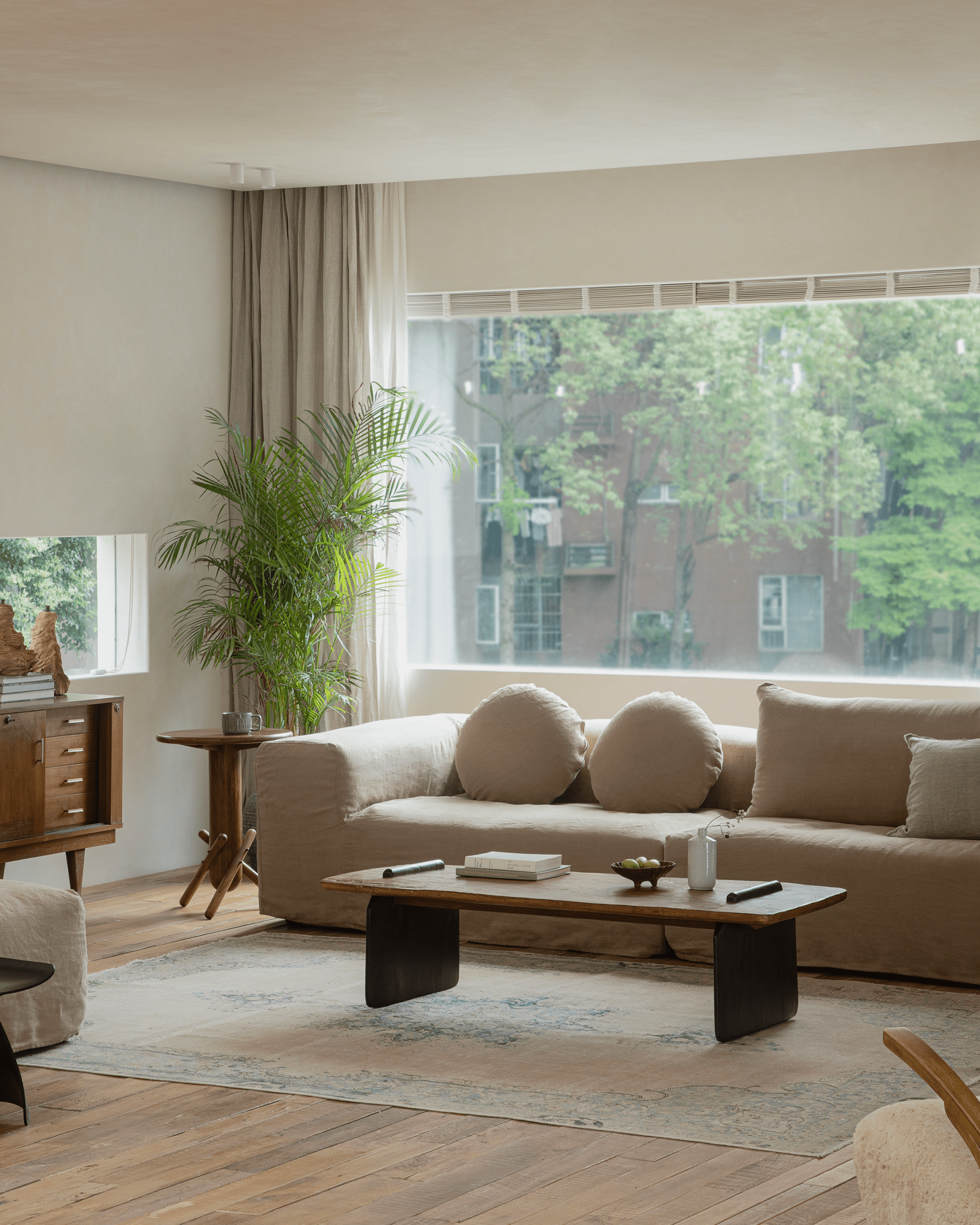 Doma sectional sofa in beige linen, wide armrests, and a relaxed living room setting