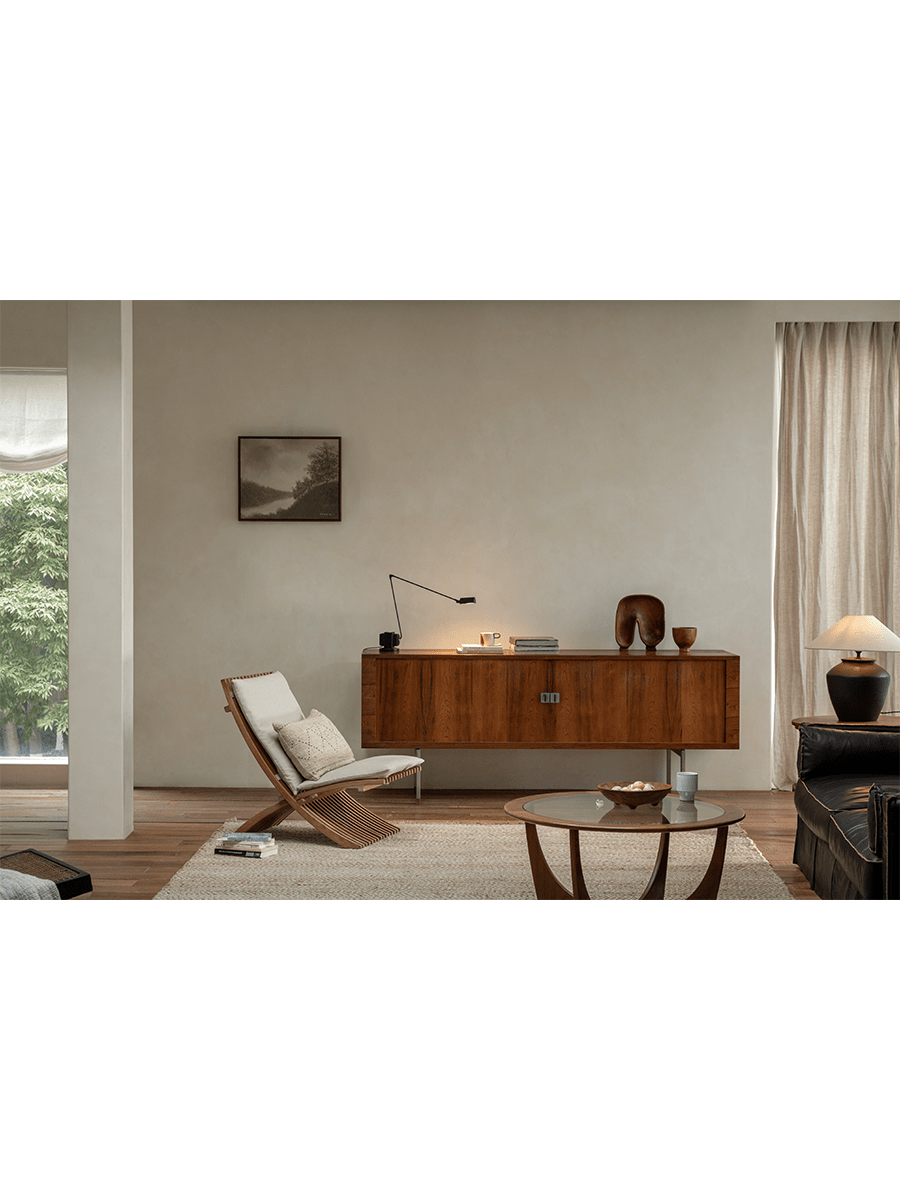 Oly Lounge Chair in a modern living room setting, showcasing the wooden slatted design, ergonomic seating, and cream cushion