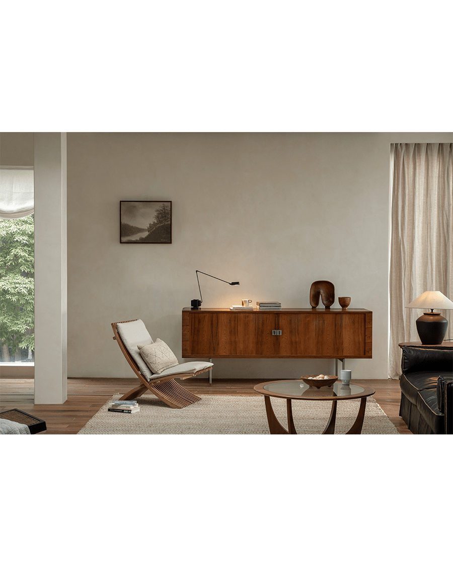 Oly Lounge Chair in a modern living room setting, showcasing the wooden slatted design, ergonomic seating, and cream cushion