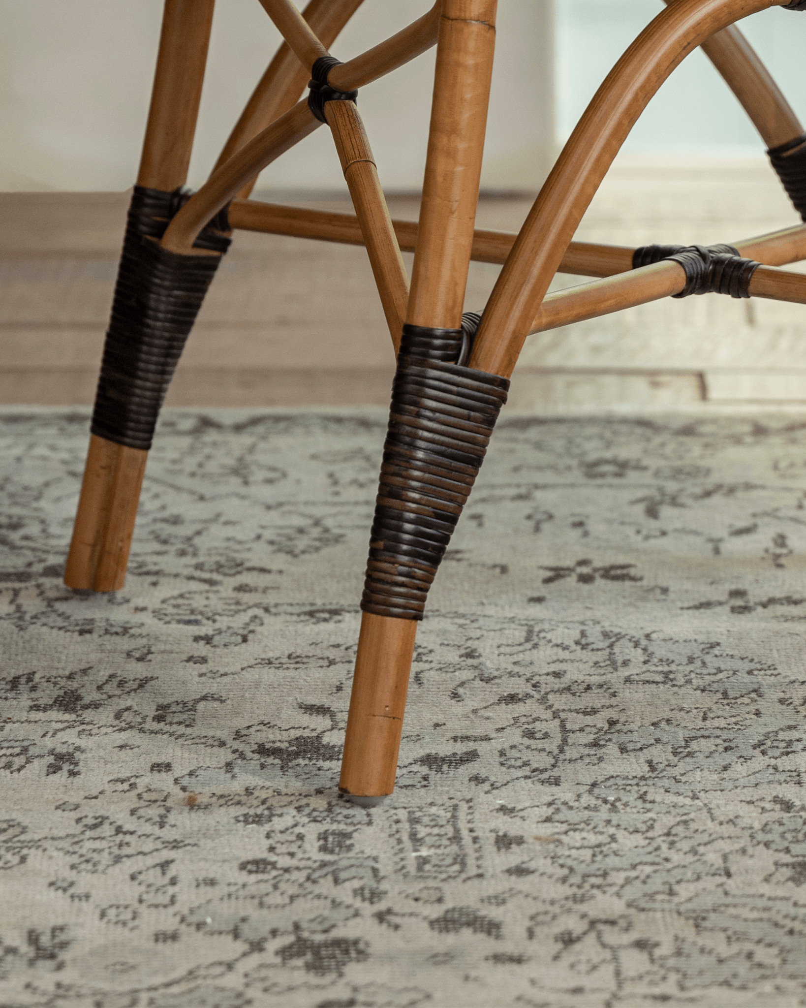 Areca Rattan Chair detail: Natural rattan legs with handwoven wrapped joints, showcasing craftsmanship.