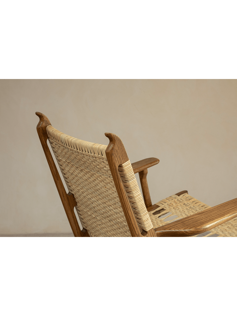Horn Lounge Chair detail, natural rattan backrest and seat, oak frame, ergonomic design, handcrafted for comfort.