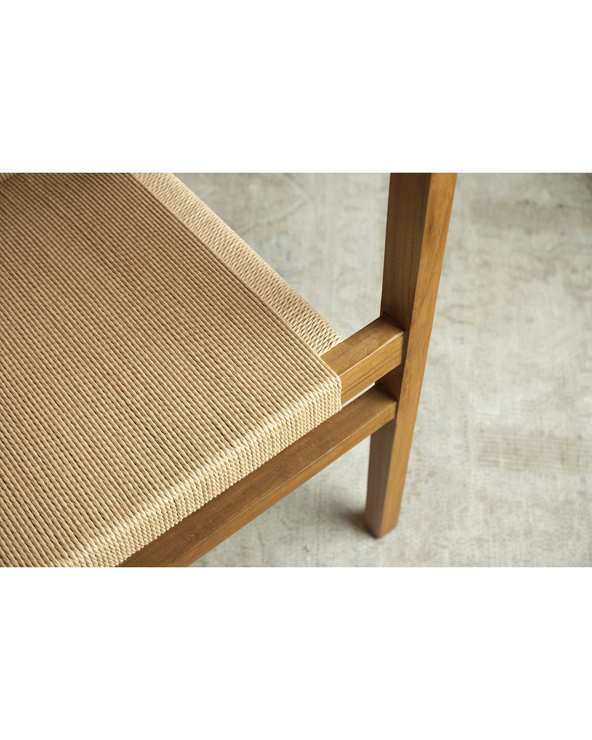 Reed Chair detail: Woven seat with teak frame. Elegant and comfortable seating option.