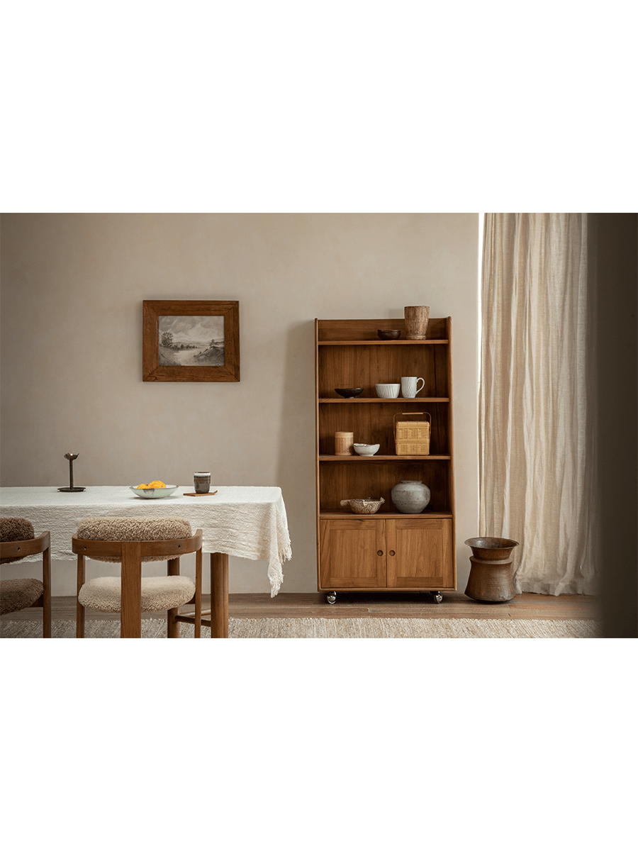 Lidi Display Cabinet in a modern interior, showcasing teak wood and adjustable shelves with wheels
