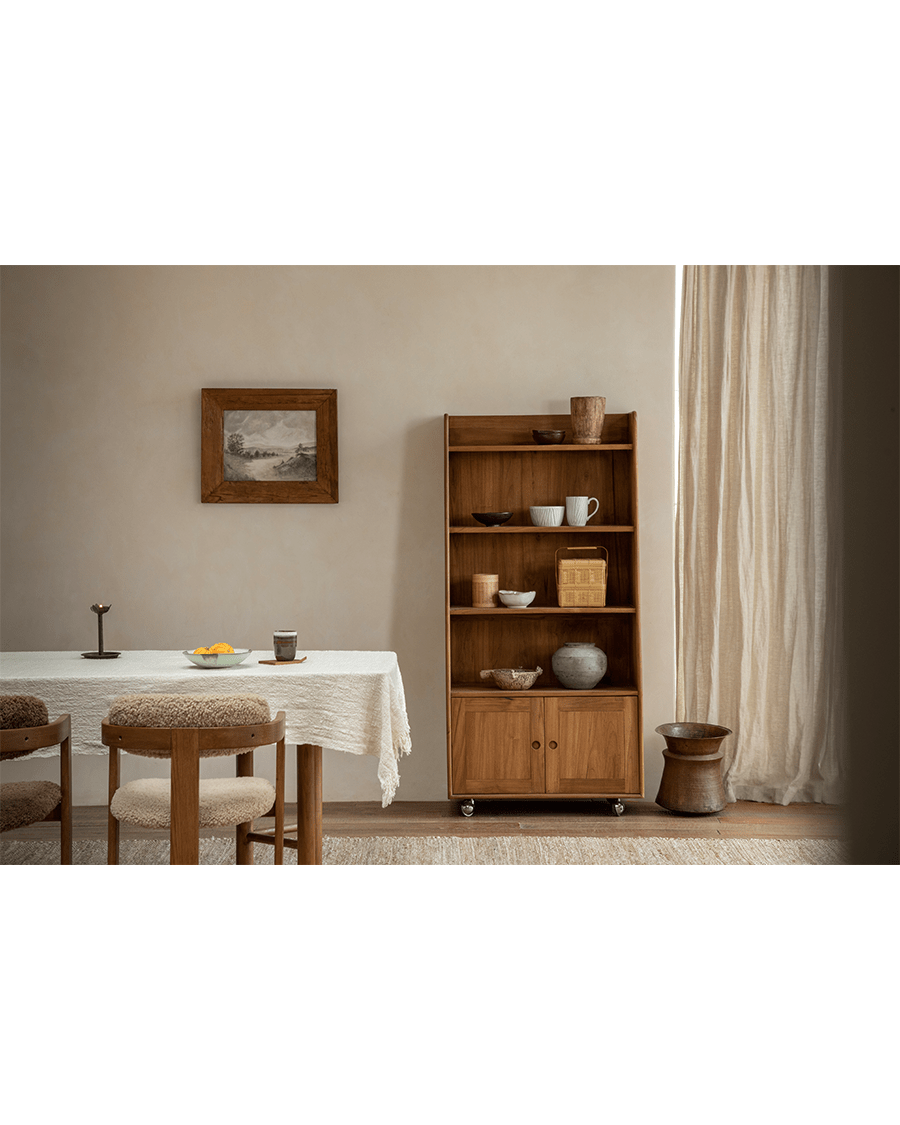 Lidi Display Cabinet in a modern interior, showcasing teak wood and adjustable shelves with wheels