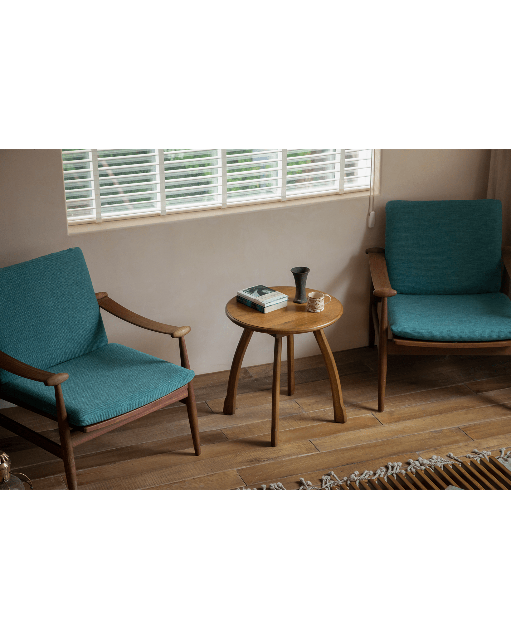 Ele Round Side Table with teal armchairs in a cozy living room, Phoebe wood table