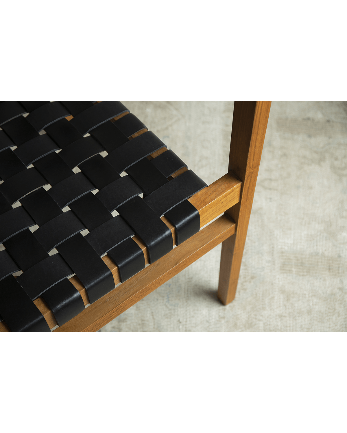 Reed Chair detail: Black leather woven seat and teak frame. Stylish and comfortable design.