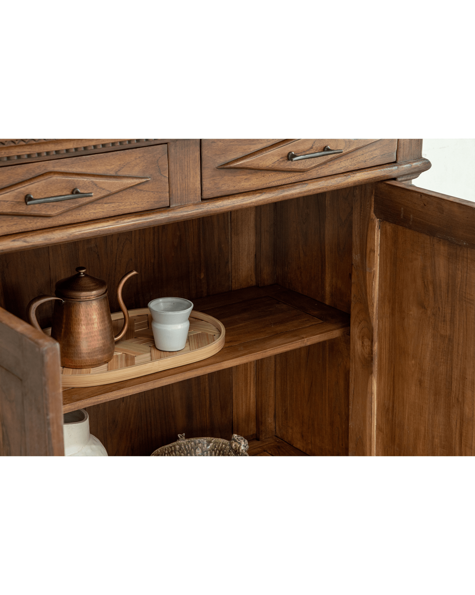 Victoria Teak Cabinet interior with carved drawers, brass handles, antique teak wood, and displayed decor.
