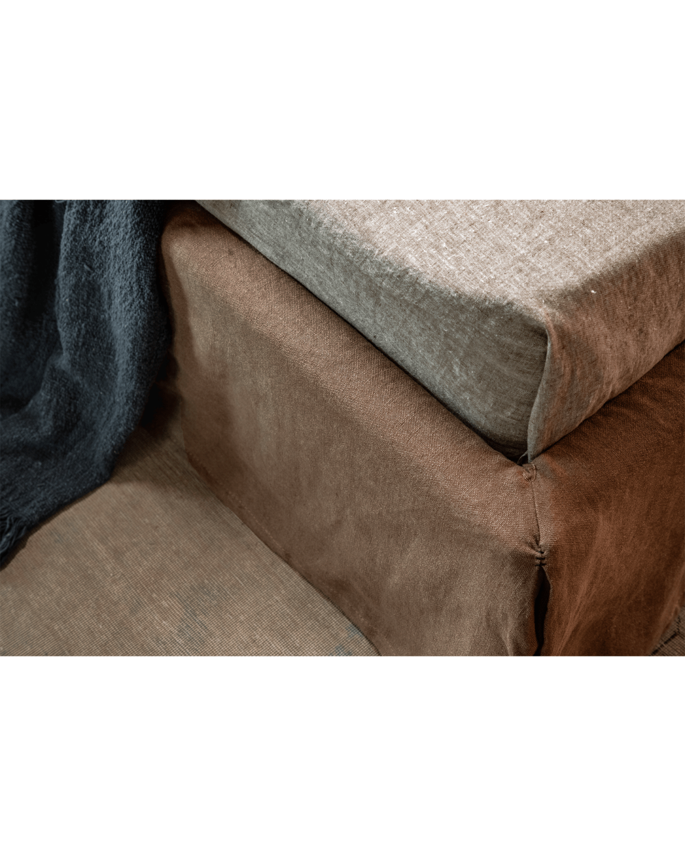 Freya Linen Bed detail: Linen upholstery in brown and light gray, showcasing soft texture and stitching.