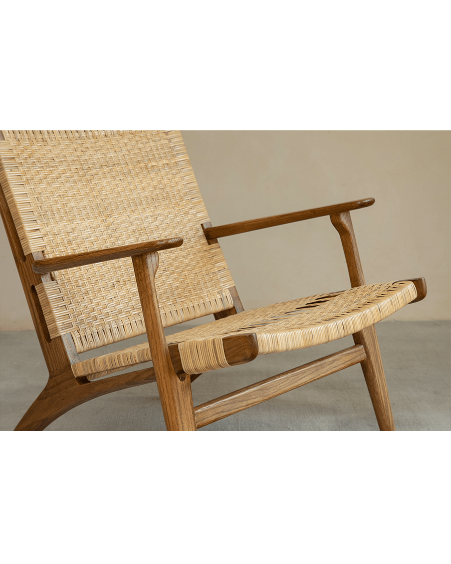 Horn Lounge Chair with oak frame and natural rattan seat, ergonomic design, handcrafted for comfort.