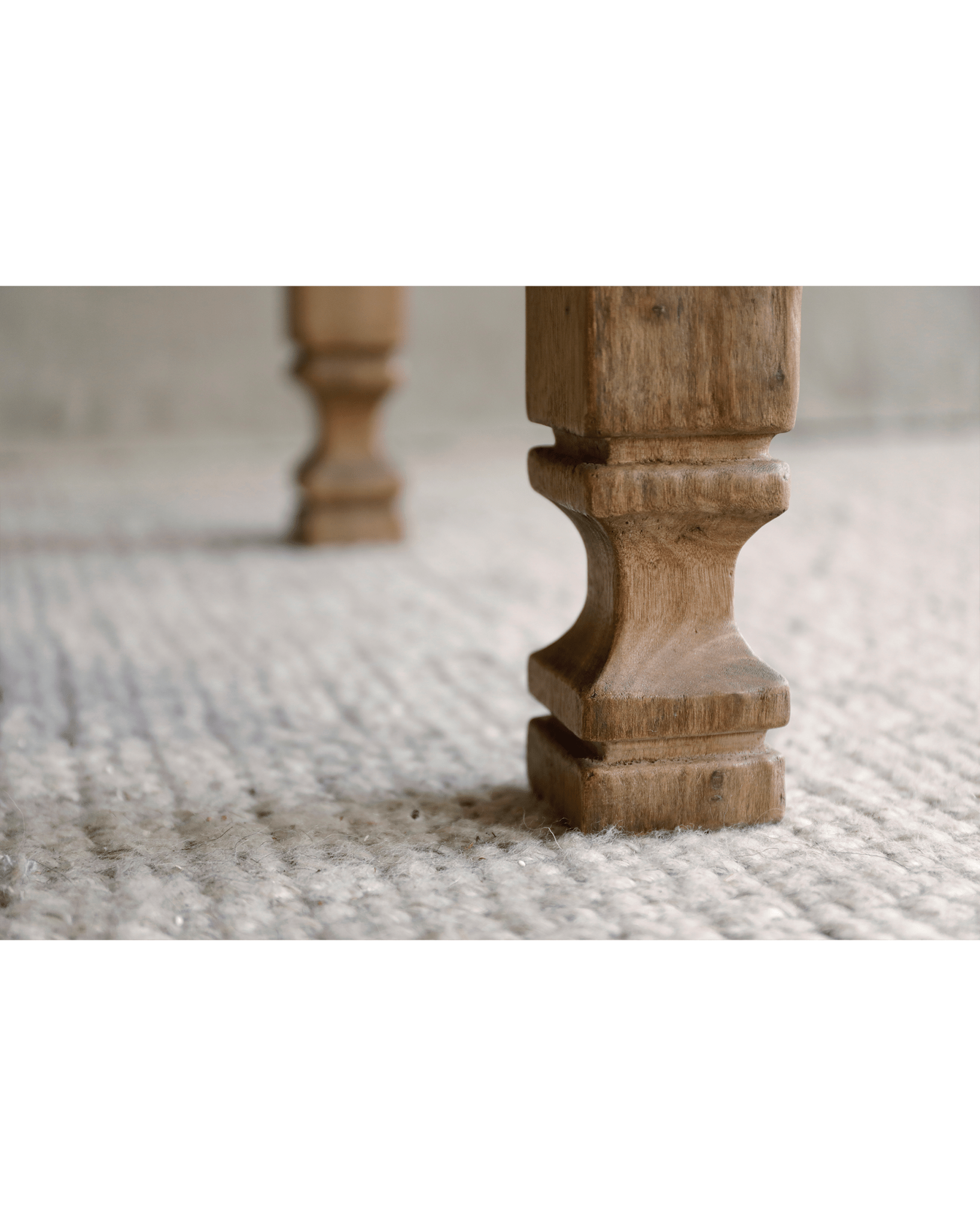 Keoni Coffee Table leg, rustic reclaimed wood design, natural finish, on a textured rug, close-up