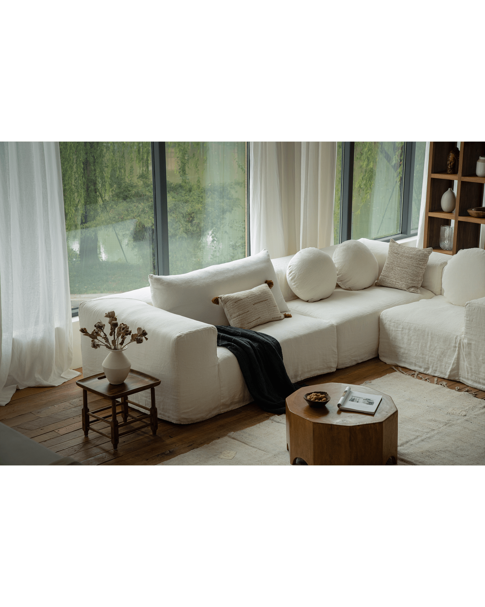 Doma sectional sofa in white linen with wide armrests, bright living room setting, featuring modular design