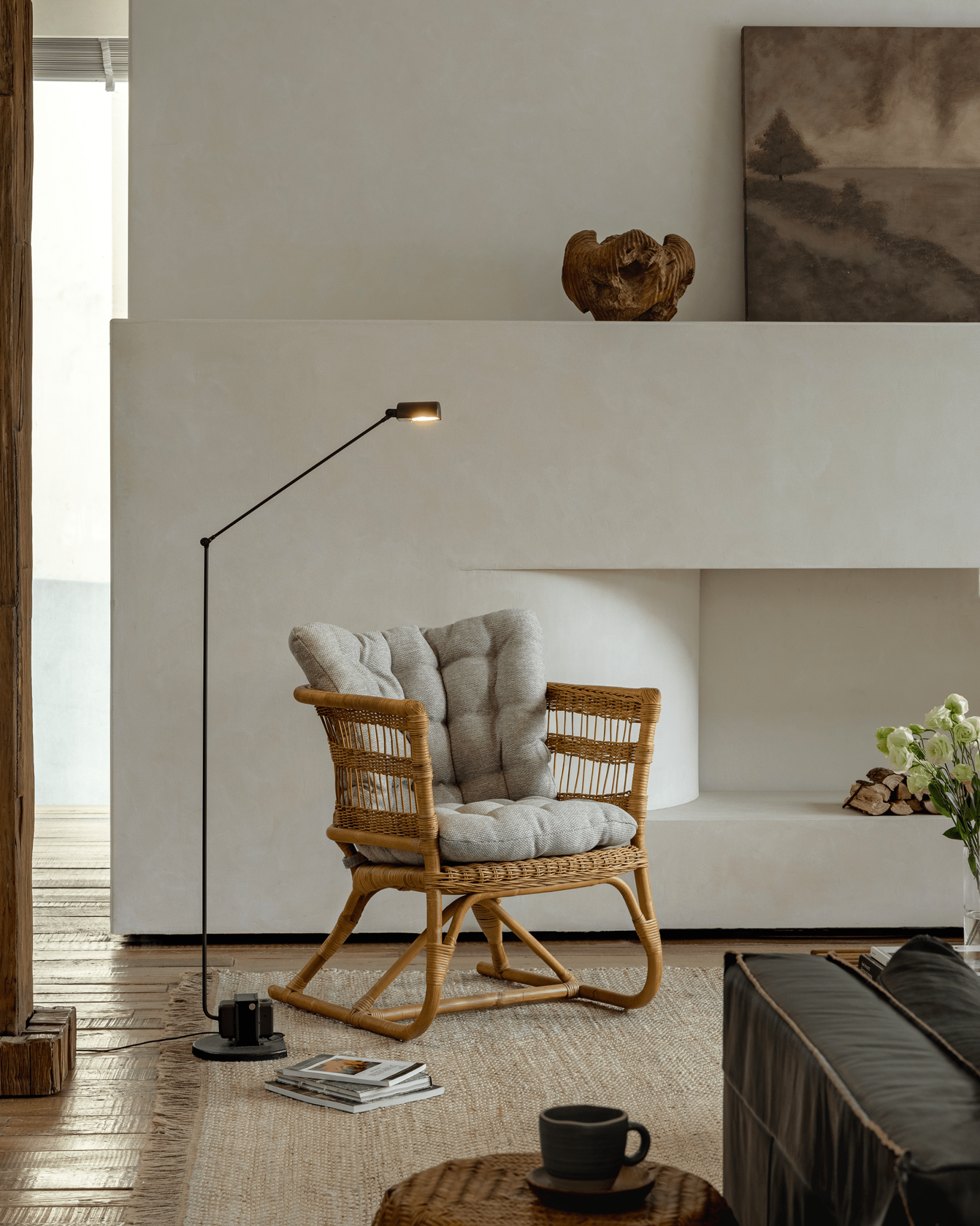 Helian Rattan Chair in cozy setting, natural rattan frame, gray cushion, and floor lamp