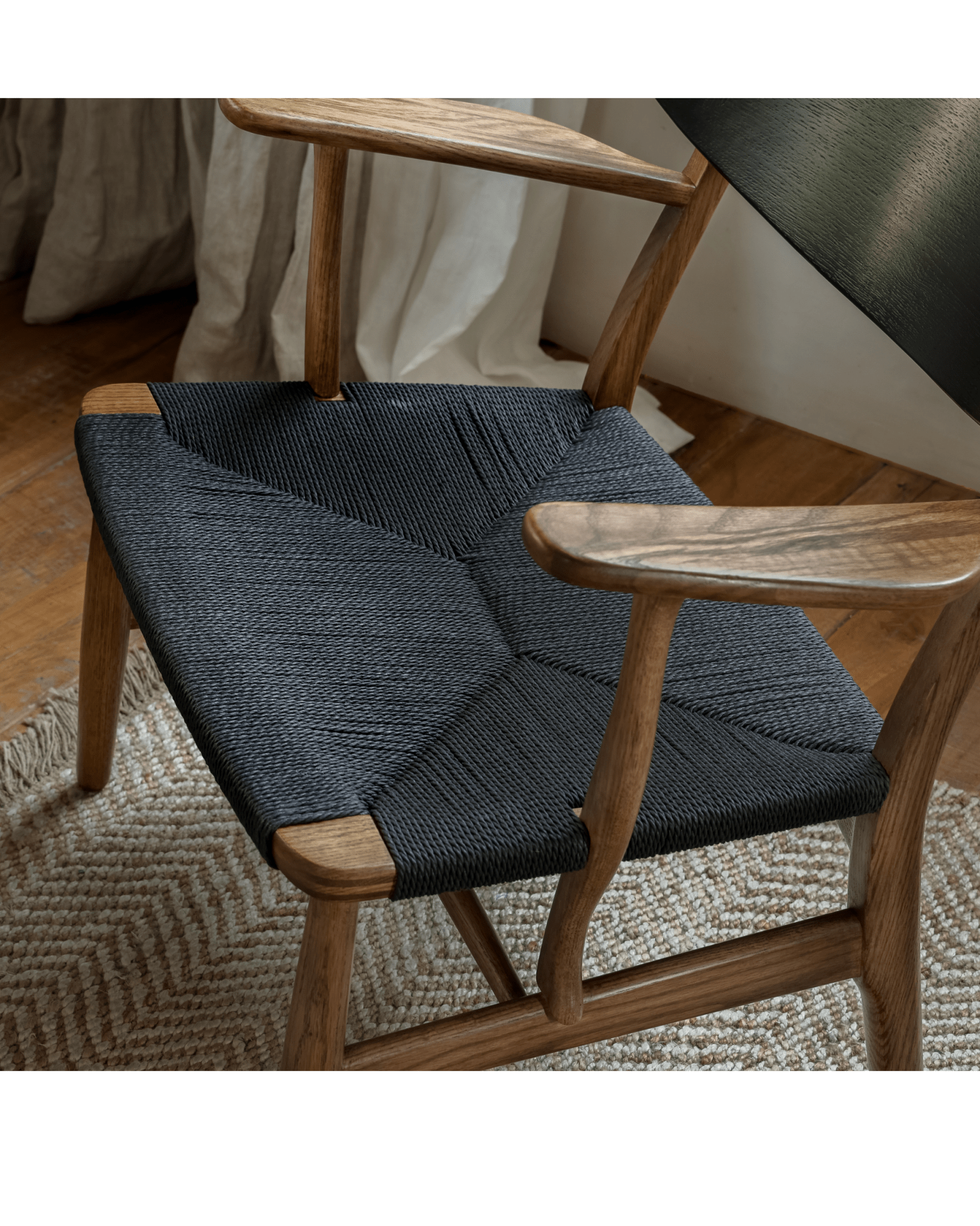 CH22 Lounge Chair with black woven paper cord seat and oak frame, Scandinavian design for modern interiors.