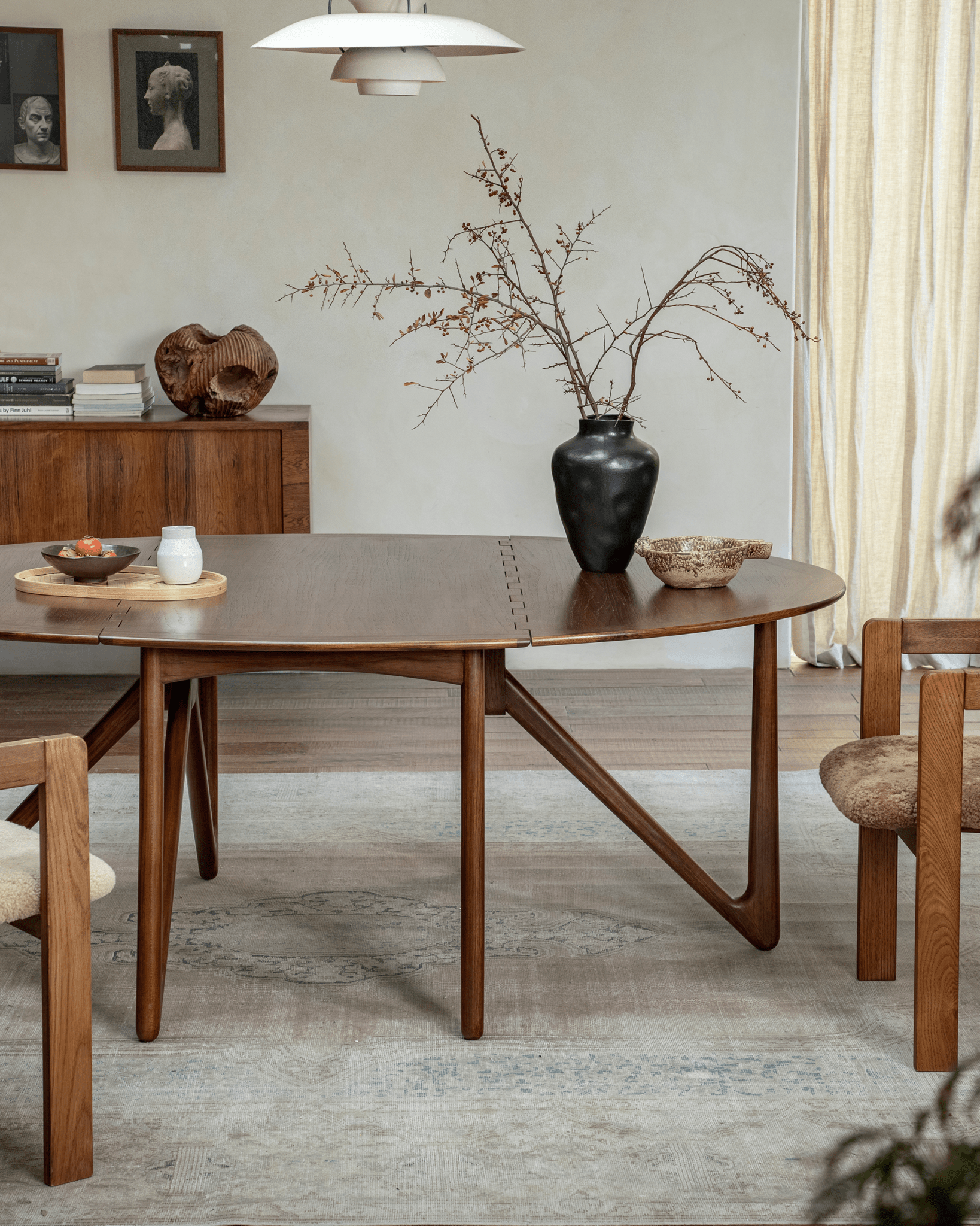 Niels Folding Table in use, extended with decor and chairs, mid-century modern design