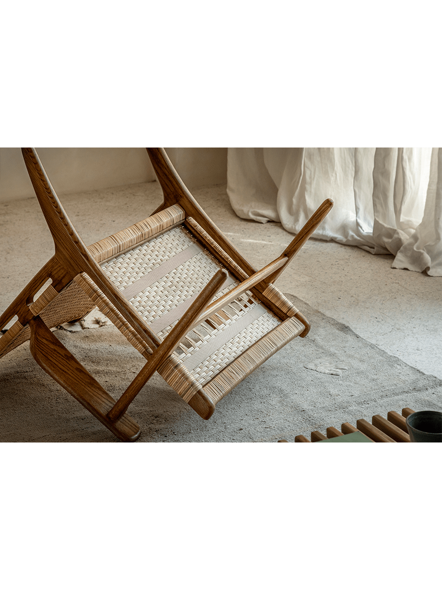 Horn Lounge Chair upside down, oak frame and natural rattan seat, showcasing construction details and ergonomic design