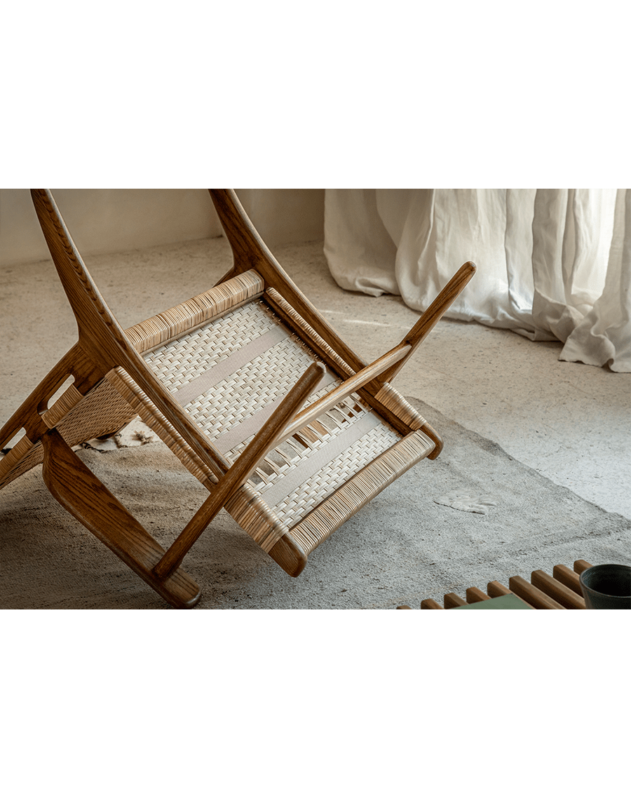 Horn Lounge Chair upside down, oak frame and natural rattan seat, showcasing construction details and ergonomic design