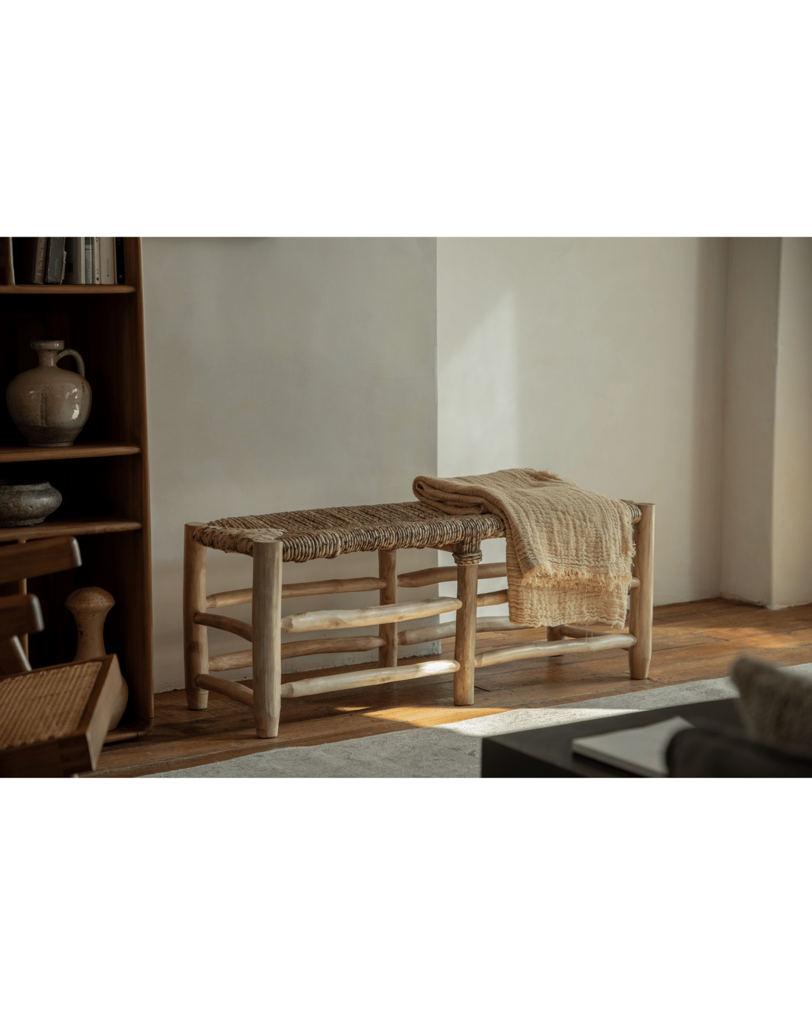 Isla Bench with woven pandan leaf seat and teak frame, featuring a woven throw, modern organic design