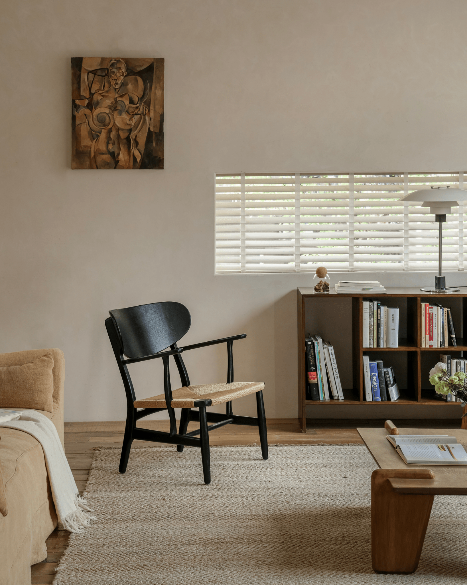 CH22 Lounge Chair in modern living room; black frame, paper cord seat, Scandinavian design