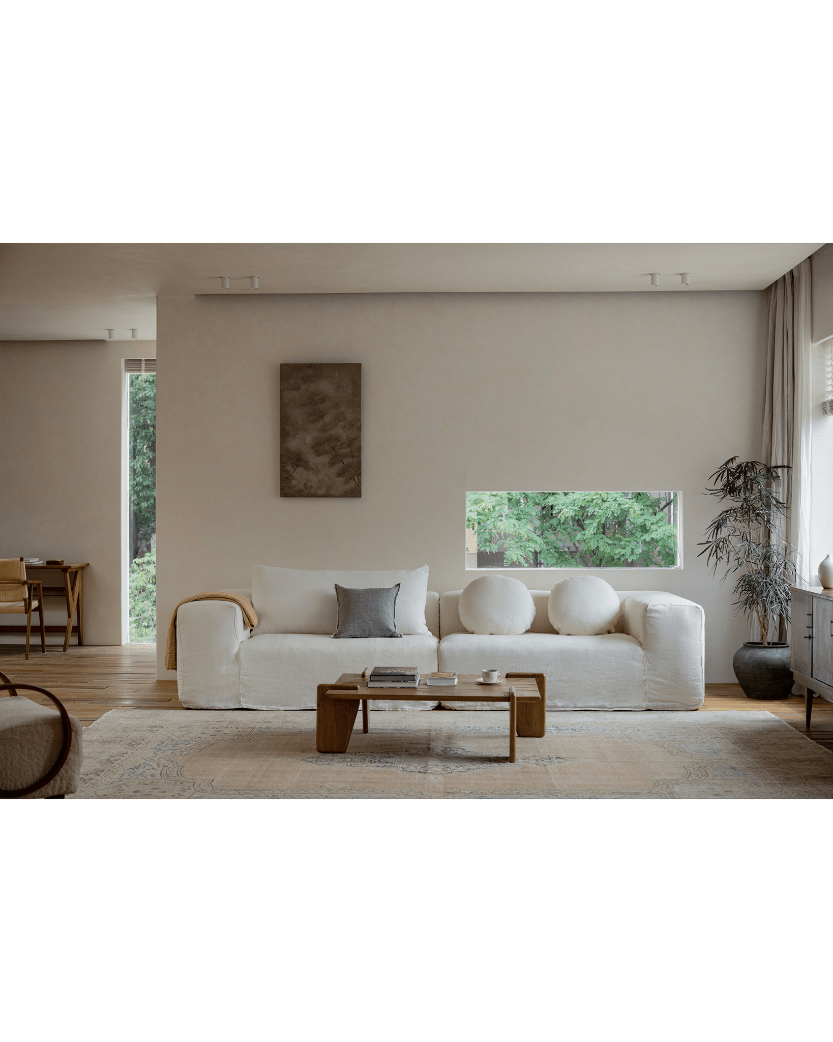 Doma Sectional Sofa in white linen with wide armrests, creating a bright and relaxed living space. Modular design.