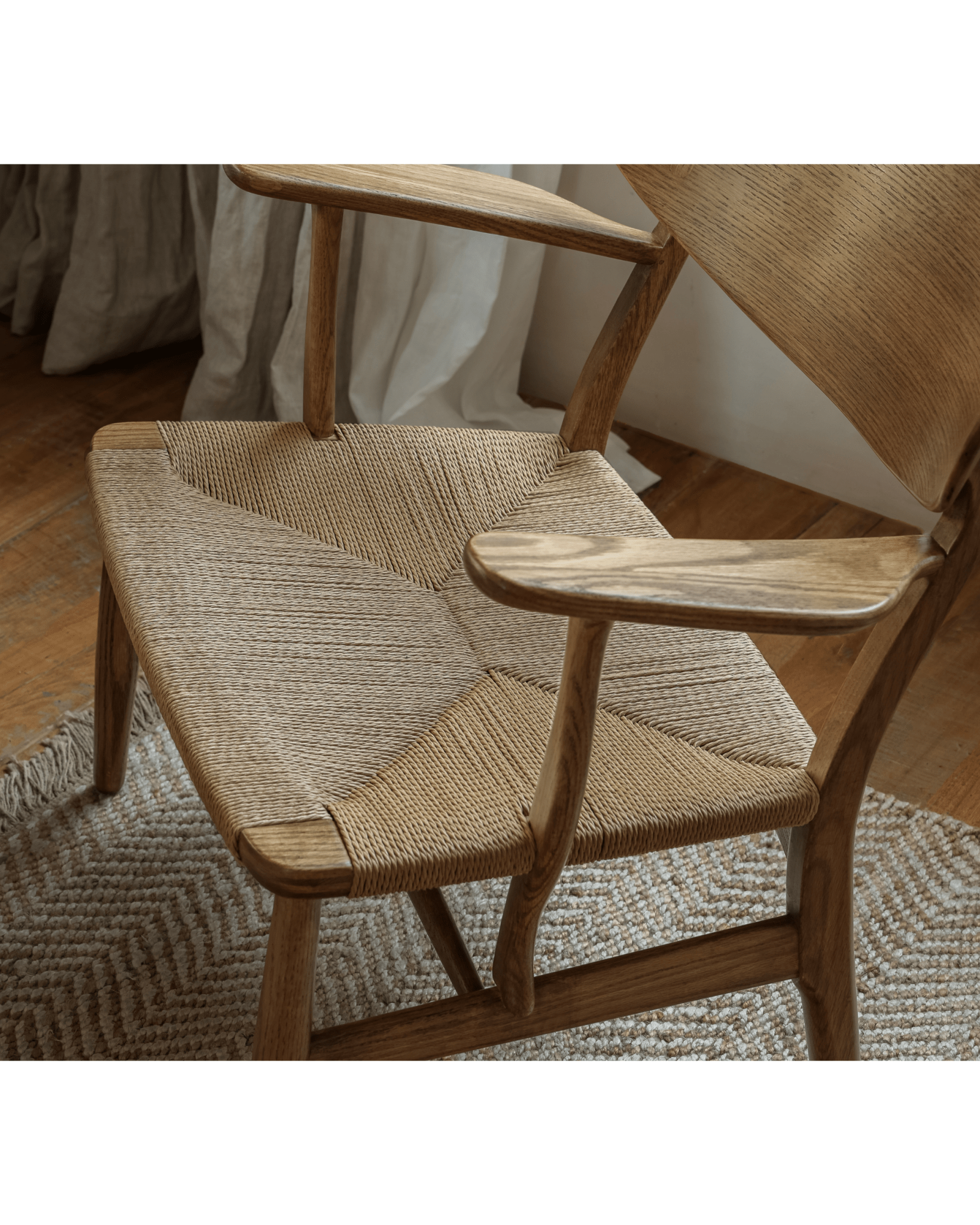 CH22 Lounge Chair in natural oak with woven paper cord seat. Scandinavian design and modern aesthetic.