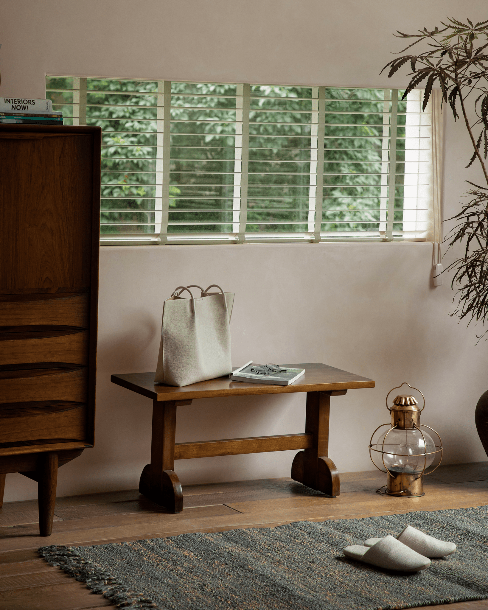 Hoof Side Table styled in retro-style living room, crafted from nanmu wood with a tote bag on the table.