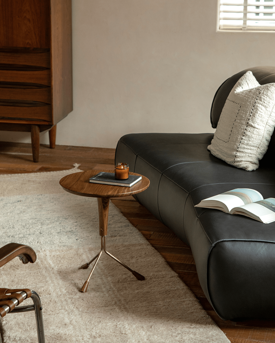 Larsson Side Table with ebony wood top and brass tripod base, modern living room design