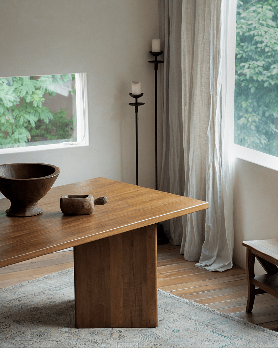 Zephyr Dining Table with a solid leg and natural wood, perfect for dining in a bright room.