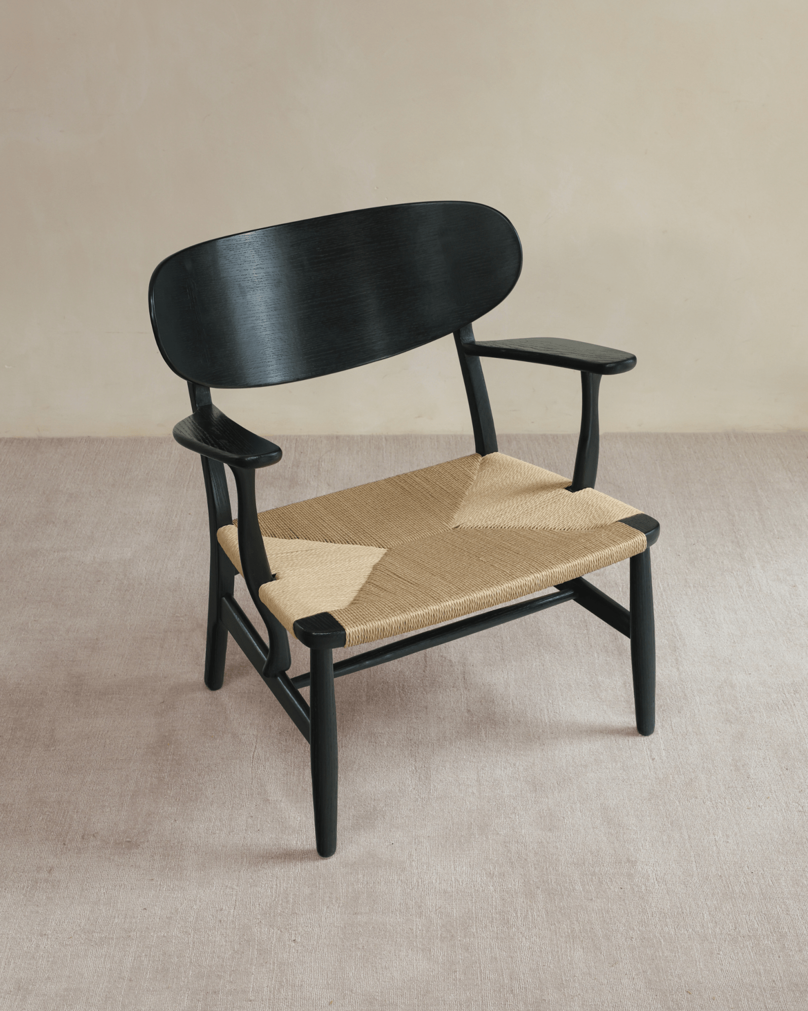 CH22 Lounge Chair with black frame and woven paper cord seat. Danish design, ergonomic, Scandinavian design