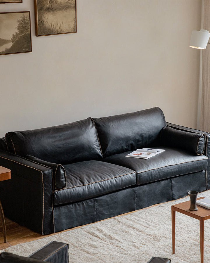 Black skirt leather sofa in a modern living room setting, highlighting premium top-grain leather and unique skirt design.